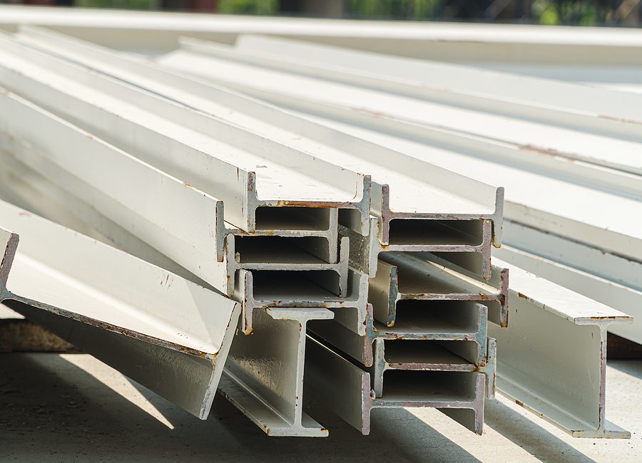 Stack of I beams on a large construction site.