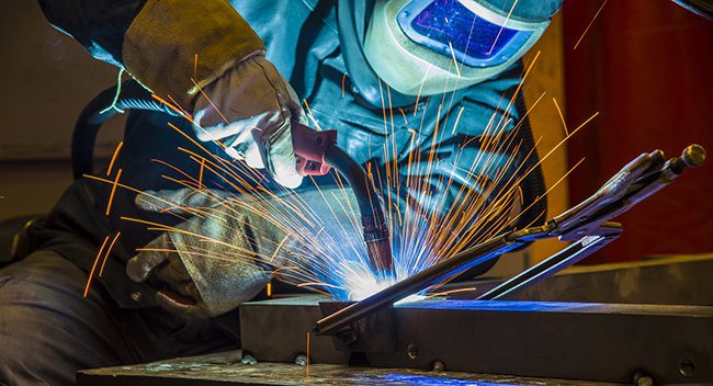 photo of a welder working, sparks flying